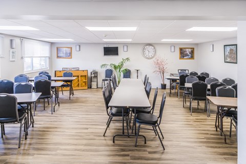 A conference room with a long table in the center and chairs surrounding it.