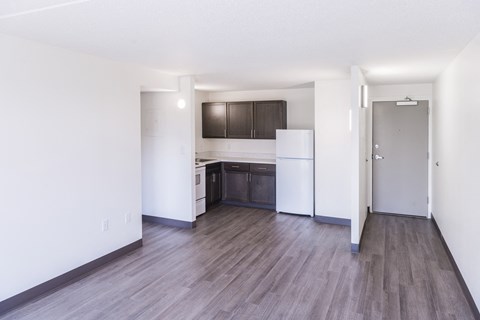 A kitchen with white cabinets and a wooden floor.