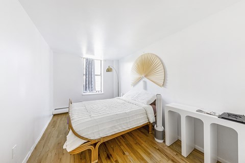 a bedroom with a bed and a dresser and a window