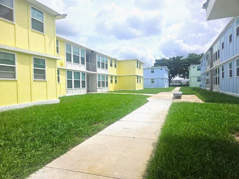 A long concrete walkway leads between two rows of identical buildings.