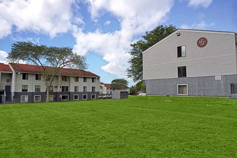 a large building with a green lawn in front of it