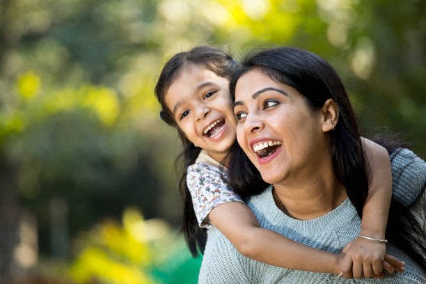 a mother and daughter laughing and hugging each other