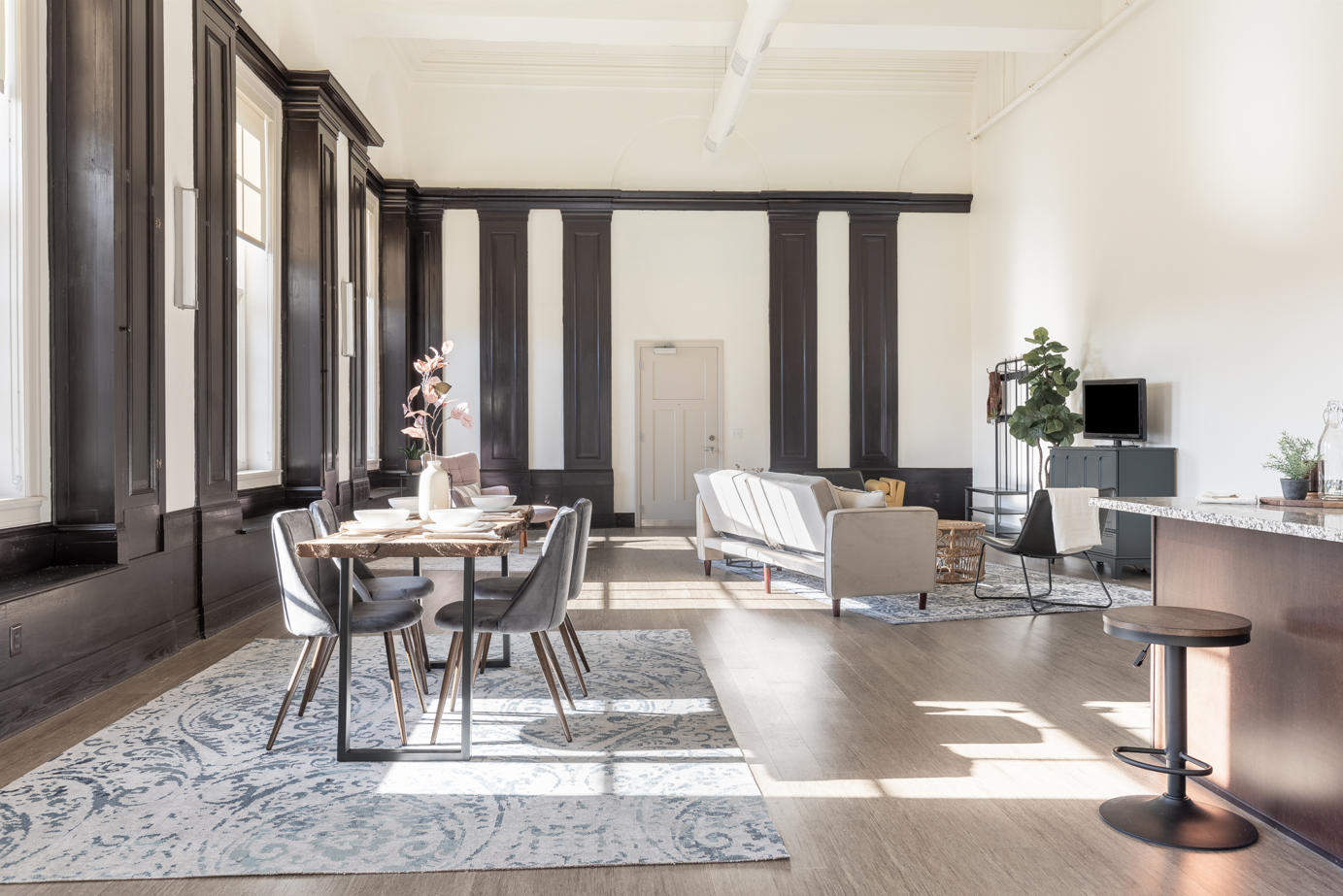 A dining room with a table set for two and a bar area.
