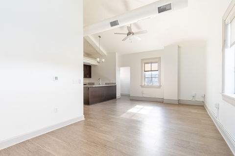 A spacious room with a ceiling fan and a window.