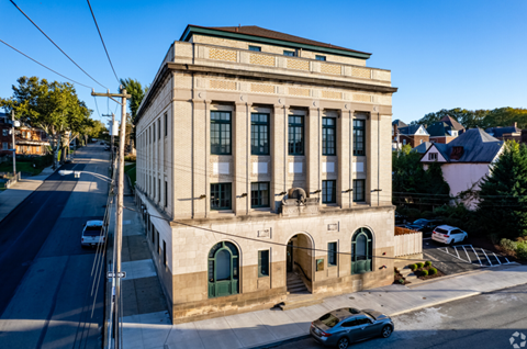 A large building with a green door sits on the corner of a street.