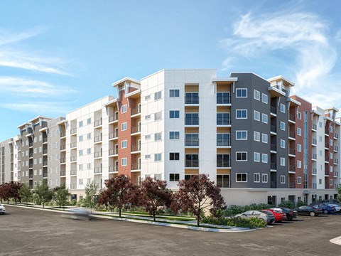A large apartment complex with a parking lot in front.