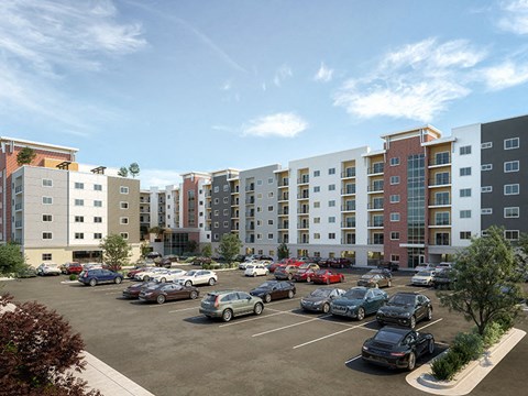 A parking lot with cars and apartment buildings in the background.