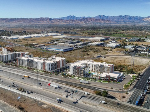 A highway with cars driving on it and buildings on the side.