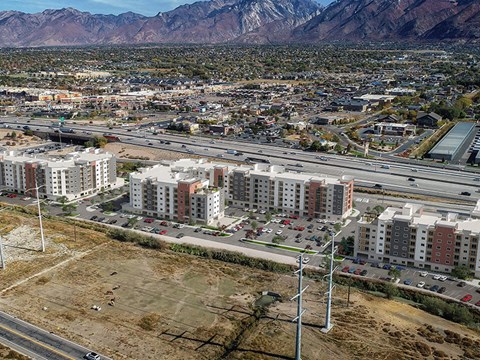 A cityscape with a large building in the foreground and mountains in the background.