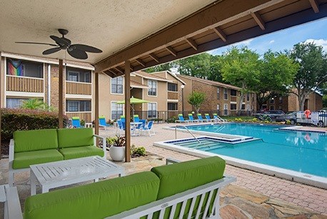 A patio with a pool and a ceiling fan.