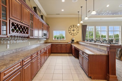 a large kitchen with wooden cabinets and a clock on the wall
