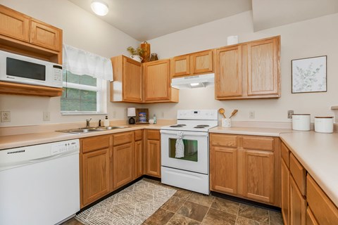 A kitchen with wooden cabinets and white appliances.
