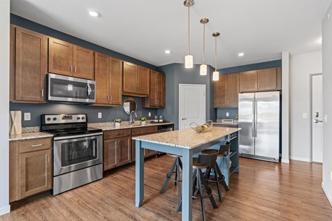 A kitchen with a table and chairs in the middle of it.