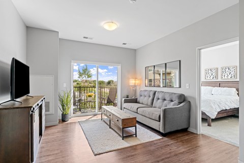 A modern living room with a grey sofa and a television.