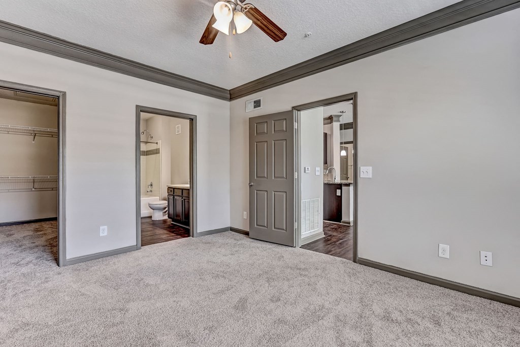 Carpeted Bedroom With Attached Bathroom & Tall Ceilings