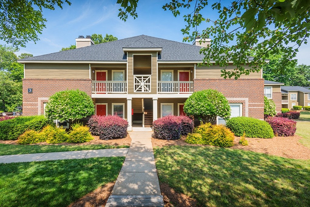 Sidewalk Leading Up To Building With Lush Landscaping