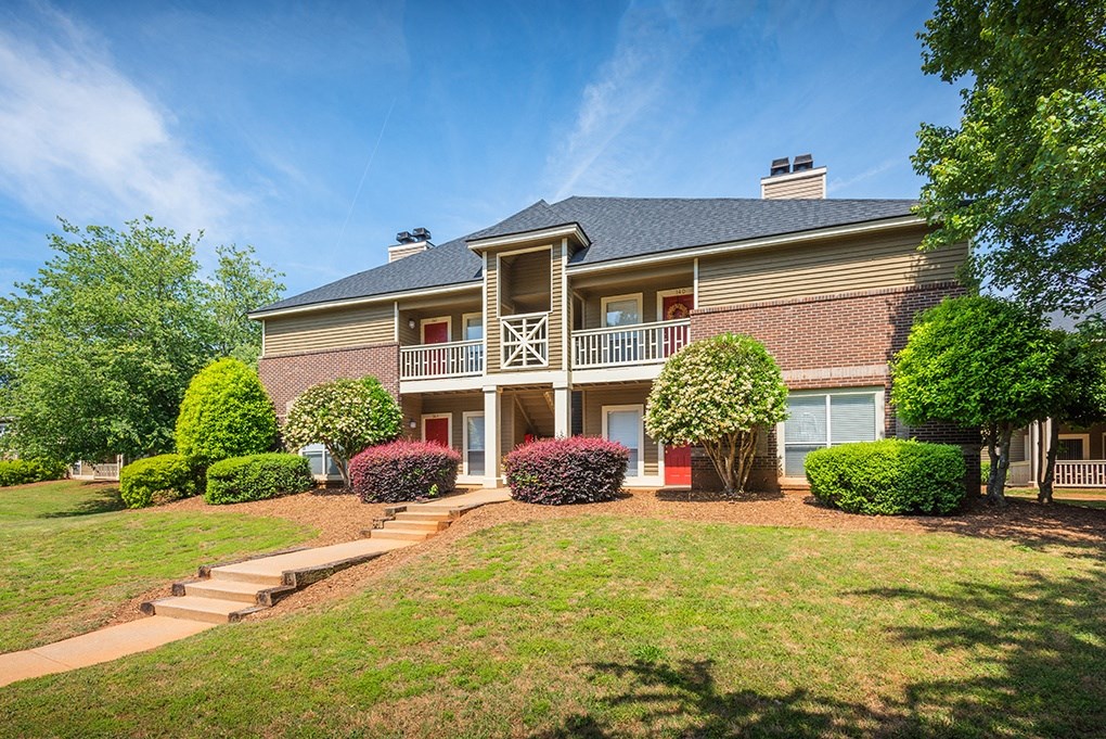 Exterior Of Apartment Homes With Lush Landscaping In Front