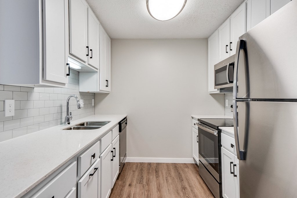 Upgraded Kitchen with White Cabinetry and Stainless Steel Appliances