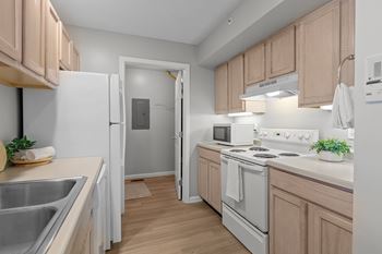 A kitchen with wooden cabinets and white appliances.