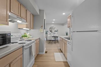 A modern kitchen with wooden cabinets and white appliances.