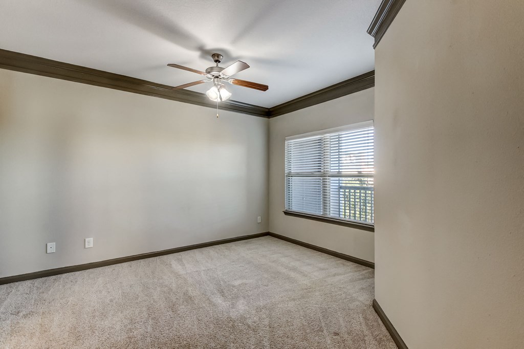 Spacious Carpeted Bedroom With Ceiling Fan