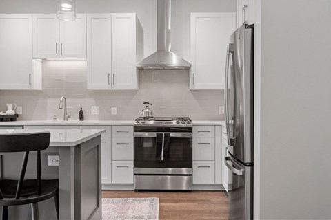a white kitchen with stainless steel appliances and white cabinets