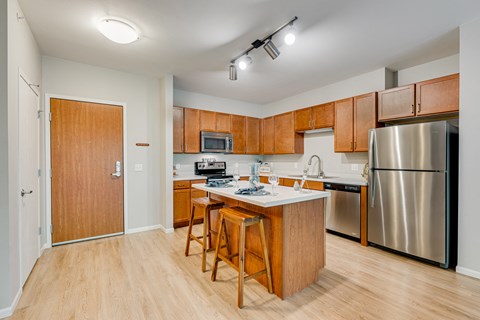 a kitchen with wooden cabinets and a stainless steel refrigerator