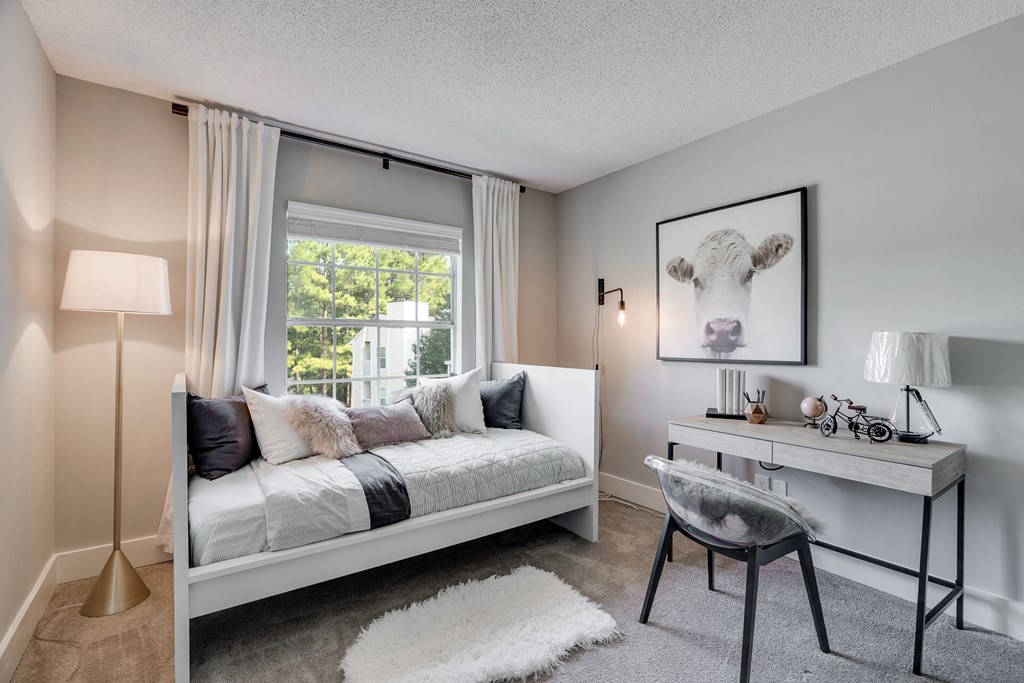 Carpeted Second Bedroom With Large Window That Lets In Lots Of Natural Light