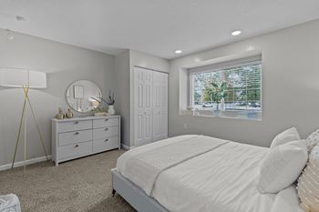 A bedroom with a bed, dresser, and mirror.