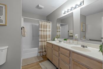 A bathroom with a white sink, a white toilet, and a shower with a curtain.