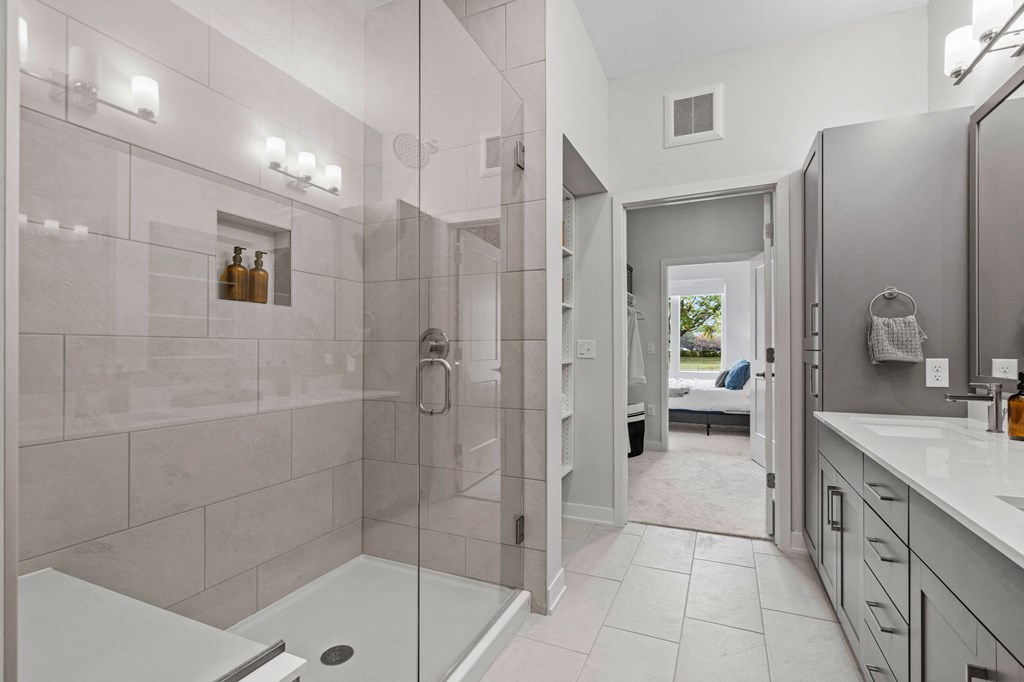 Primary Bathroom Featuring Glass Shower With Bench & Tiled Floor