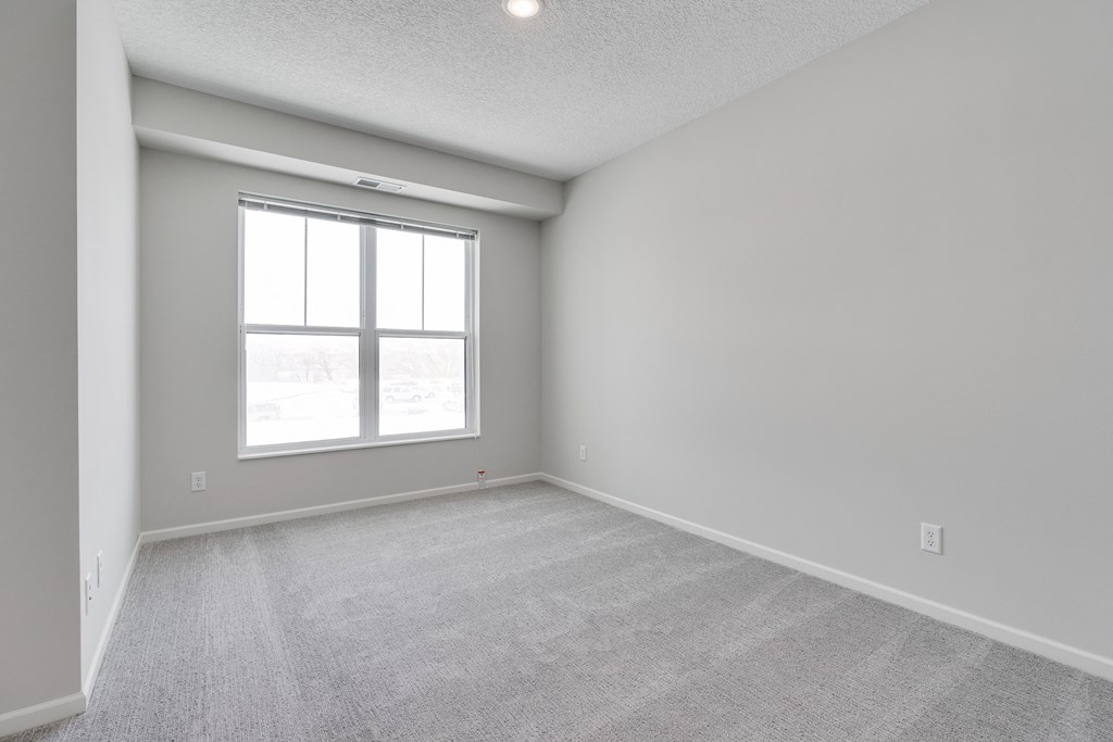 Bedroom Featuring Plush Carpeting & Large Windows