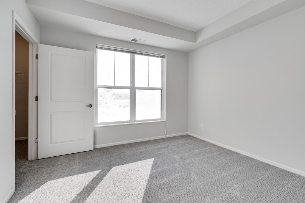Bedroom With Large Windows & Attached Walk-In Closet