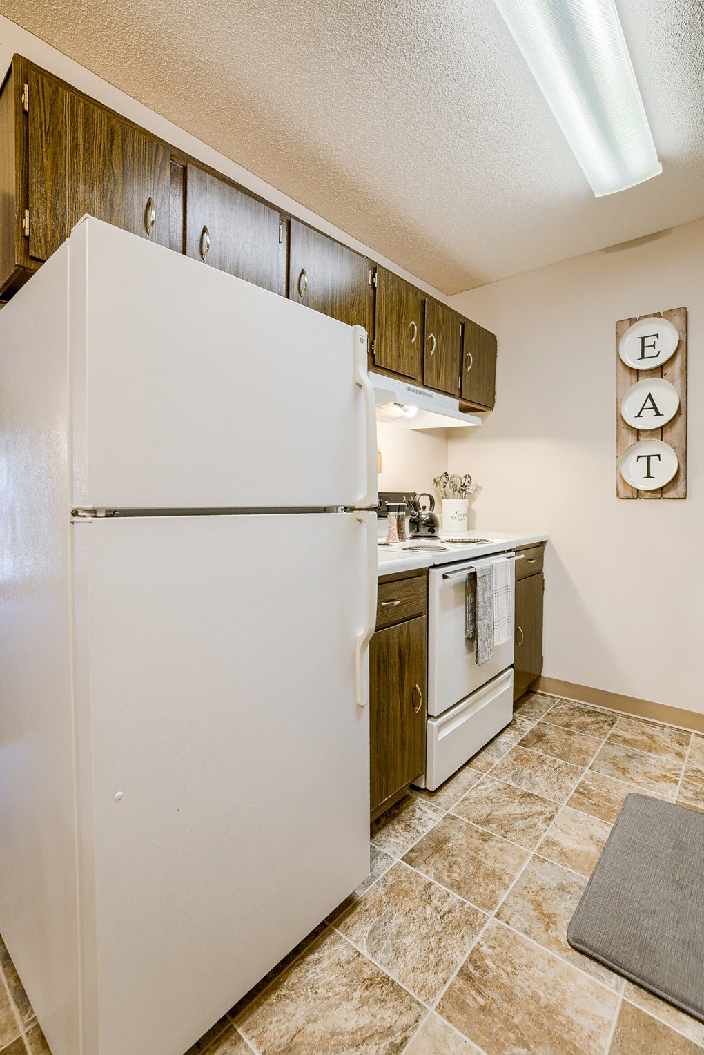 a kitchen with white appliances and a refrigerator
