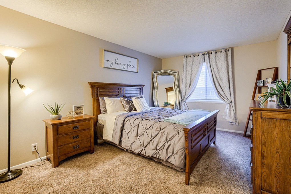 a bedroom with a bed and a dresser and a window