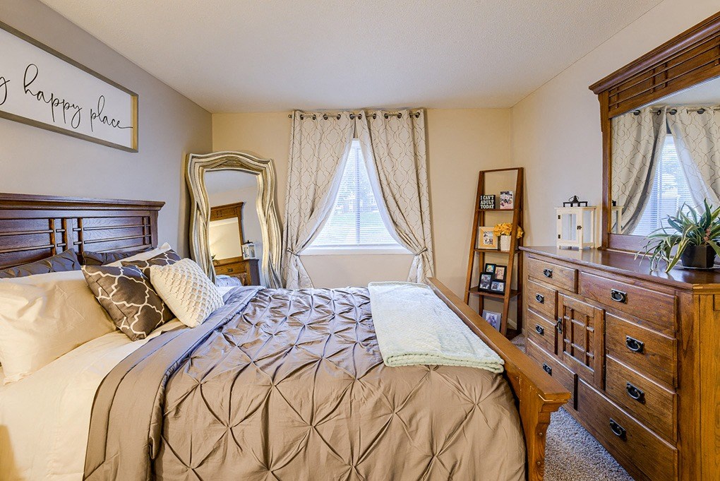 a bedroom with a bed and a dresser and a window