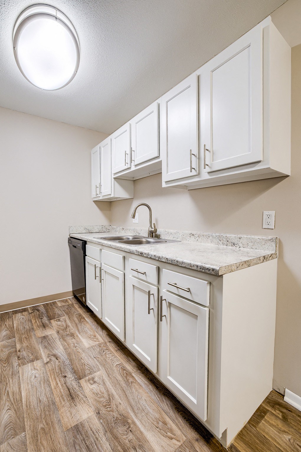 a kitchen with white cabinets and a counter top and a sink