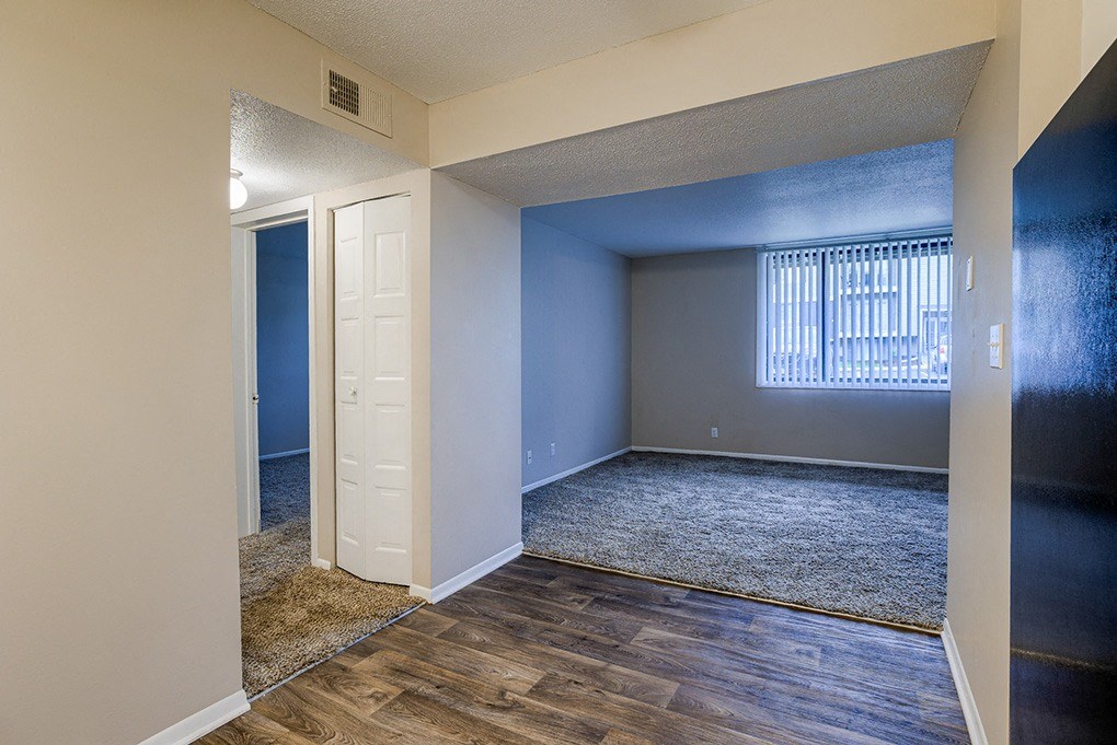 an empty living room with a window and a door
