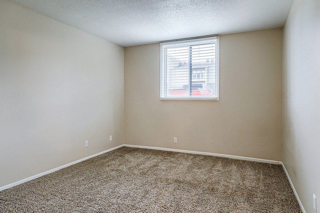 an empty room with carpet and a window