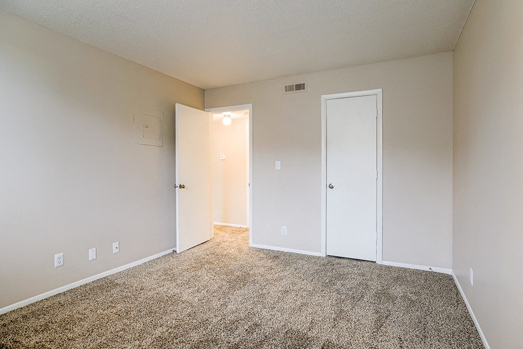 an empty room with a carpeted floor and white doors