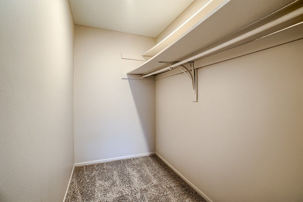 an empty room with a closet and a hanger on the wall