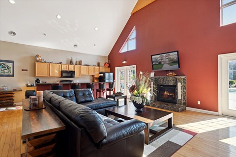 a living room with red walls and leather furniture and a fireplace