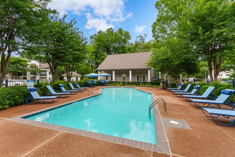 A large swimming pool surrounded by blue lounge chairs.