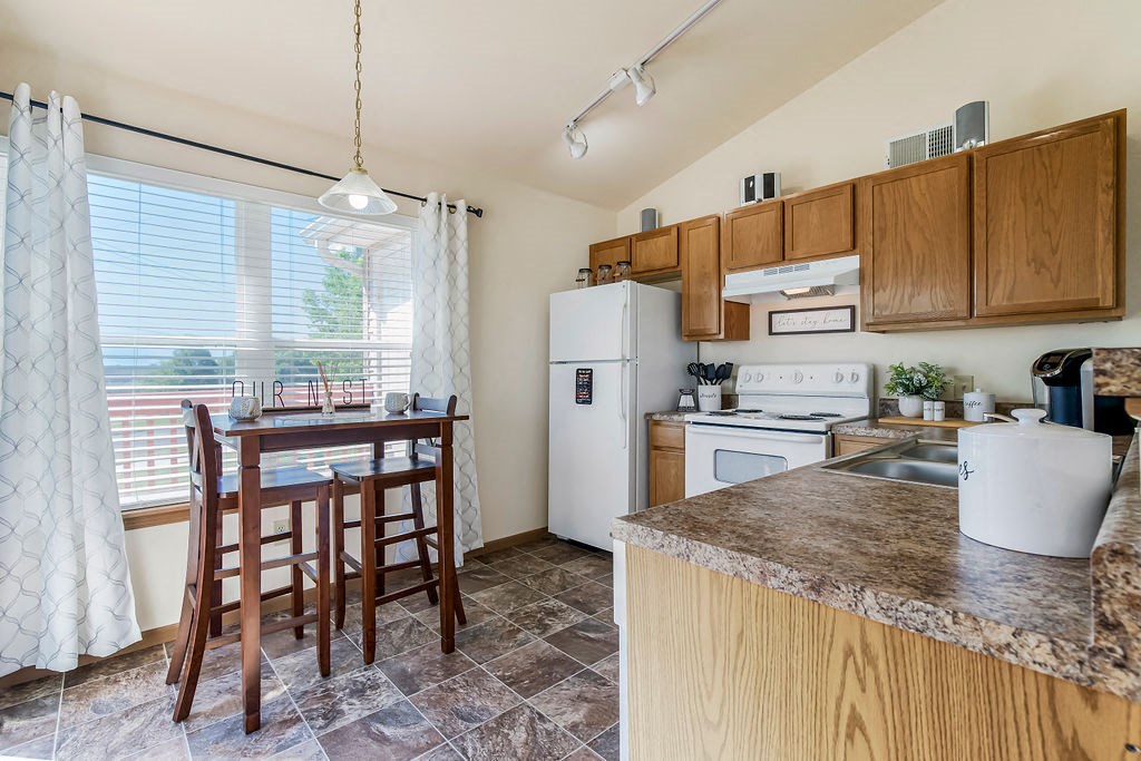Kitchen With Vaulted Ceilings & White Appliances