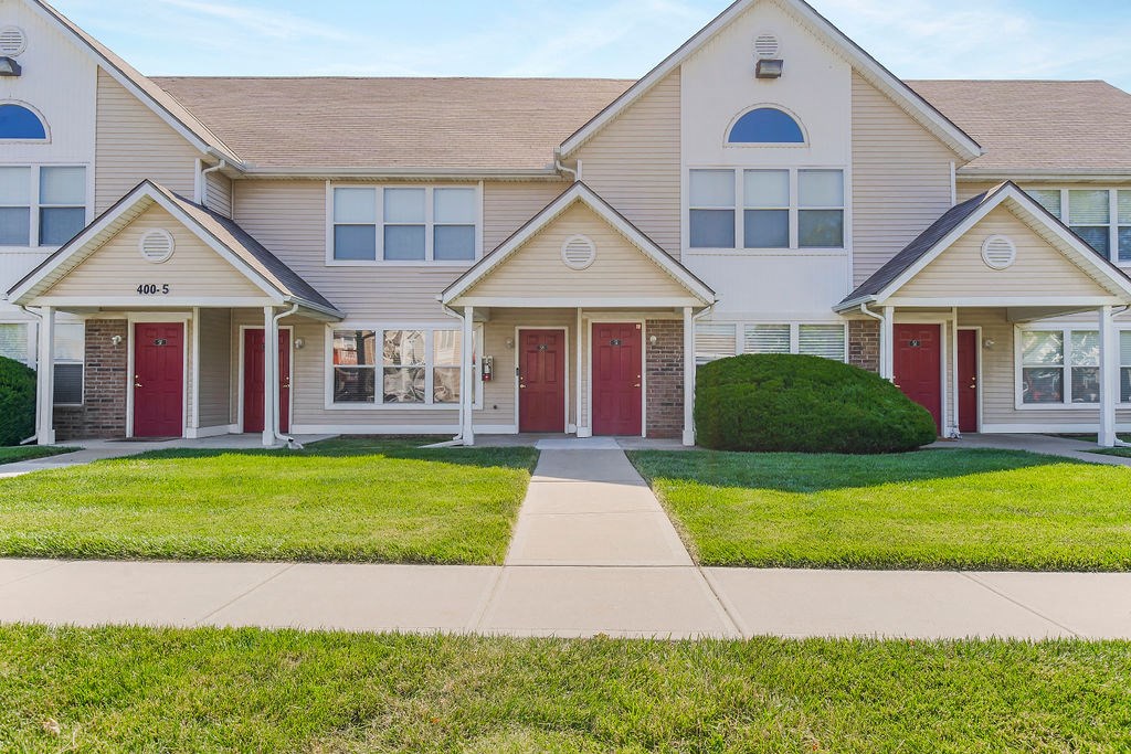Lush Grass Area In Front Of Apartment Homes With Private Entrances