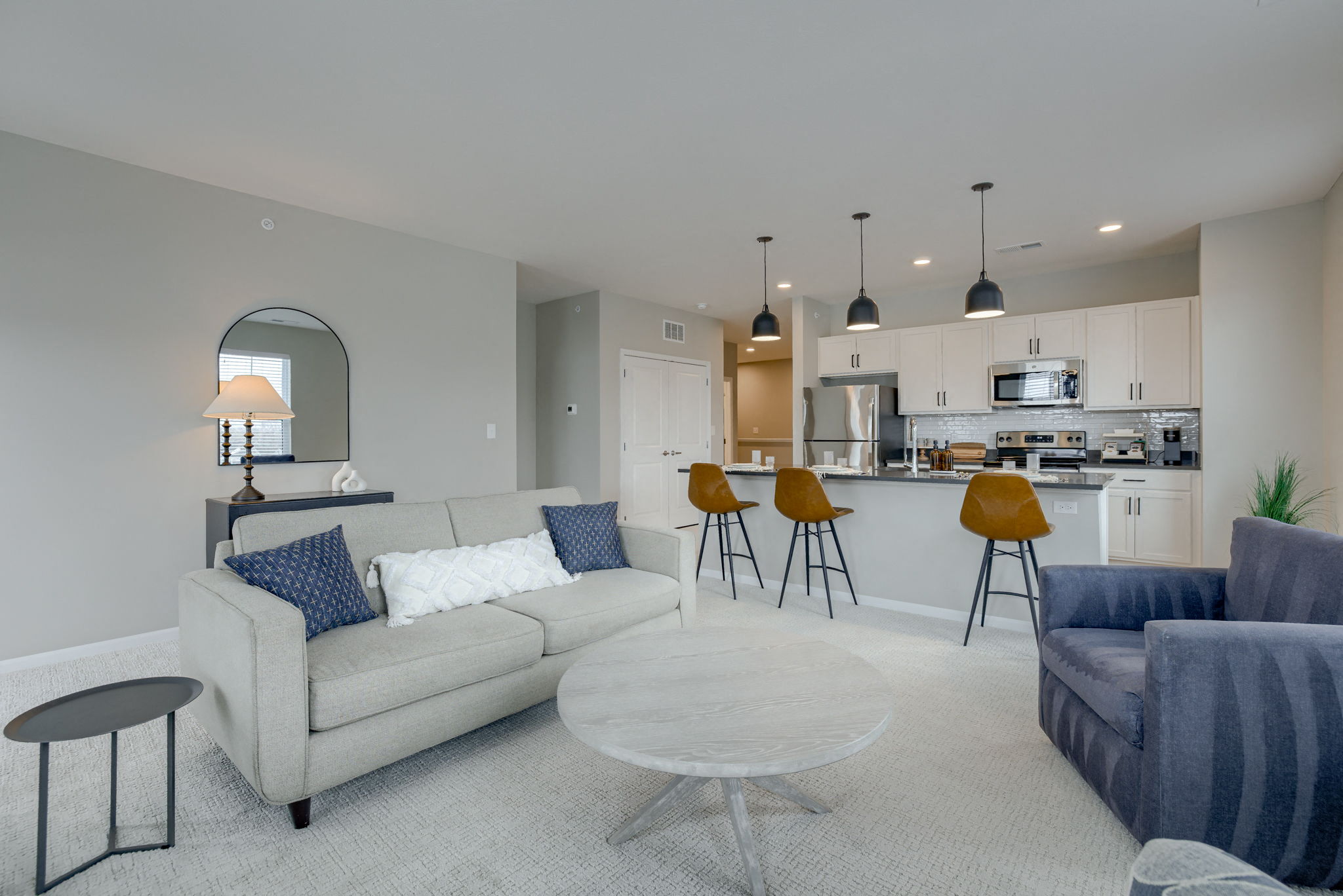 a living room and kitchen with a couch and a table