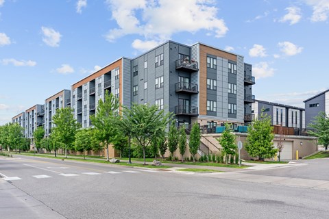 Apartment buildings with balconies line a street.