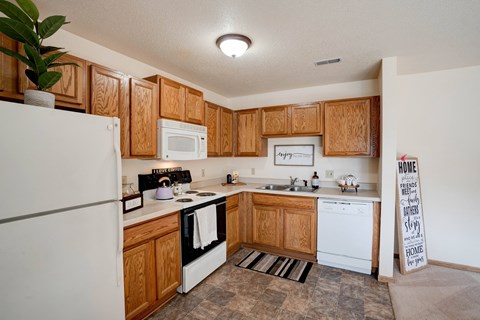 a kitchen with white appliances and wooden cabinets