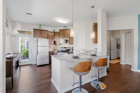 a kitchen with an island and a bar with two chairs