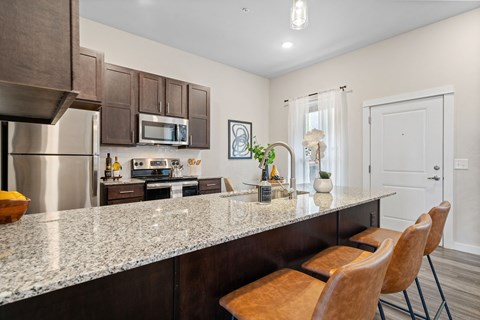 a kitchen with a granite counter top and stainless steel appliances